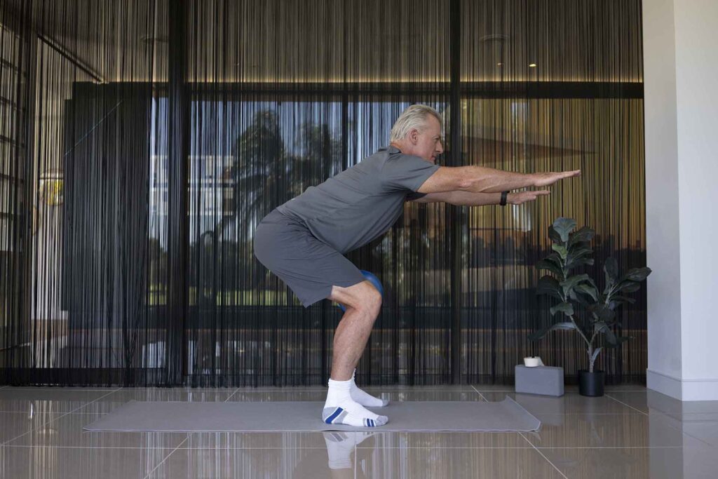 Man performing a squat exercise to strengthen his pelvic floor